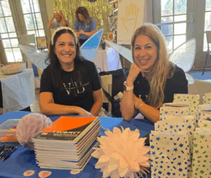 Two women at a table with school supplies